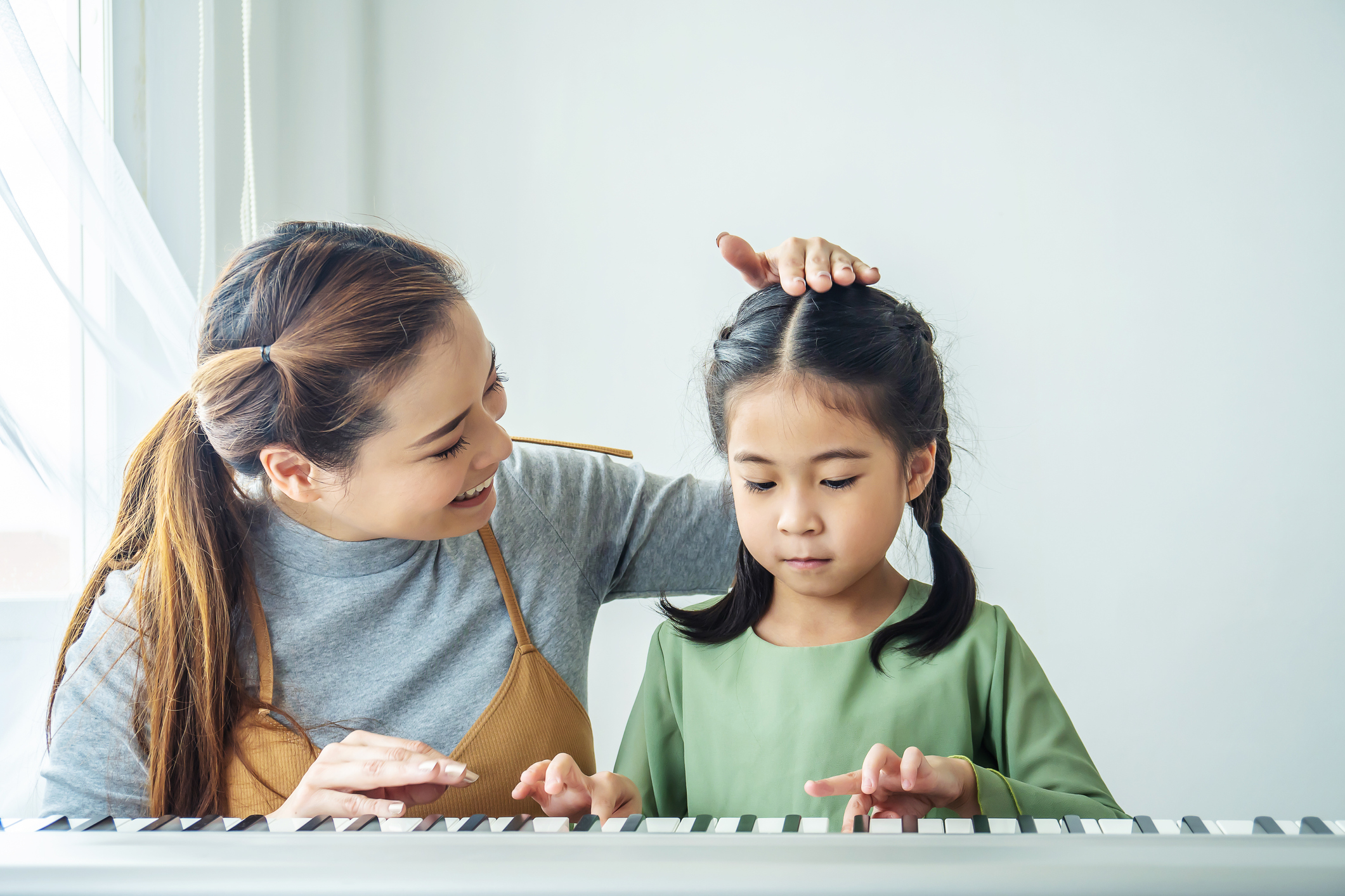Happy little Asian deaughter playing piano with mother at home, Mother teaching daughter to play piano,They play and sing songs. They are having fun. 目前職場仍存在著低薪的窘況,所以也讓不少畢業生猶豫著:究竟自己應該繼續升學?還是該接受低薪的事實選擇投入職場?